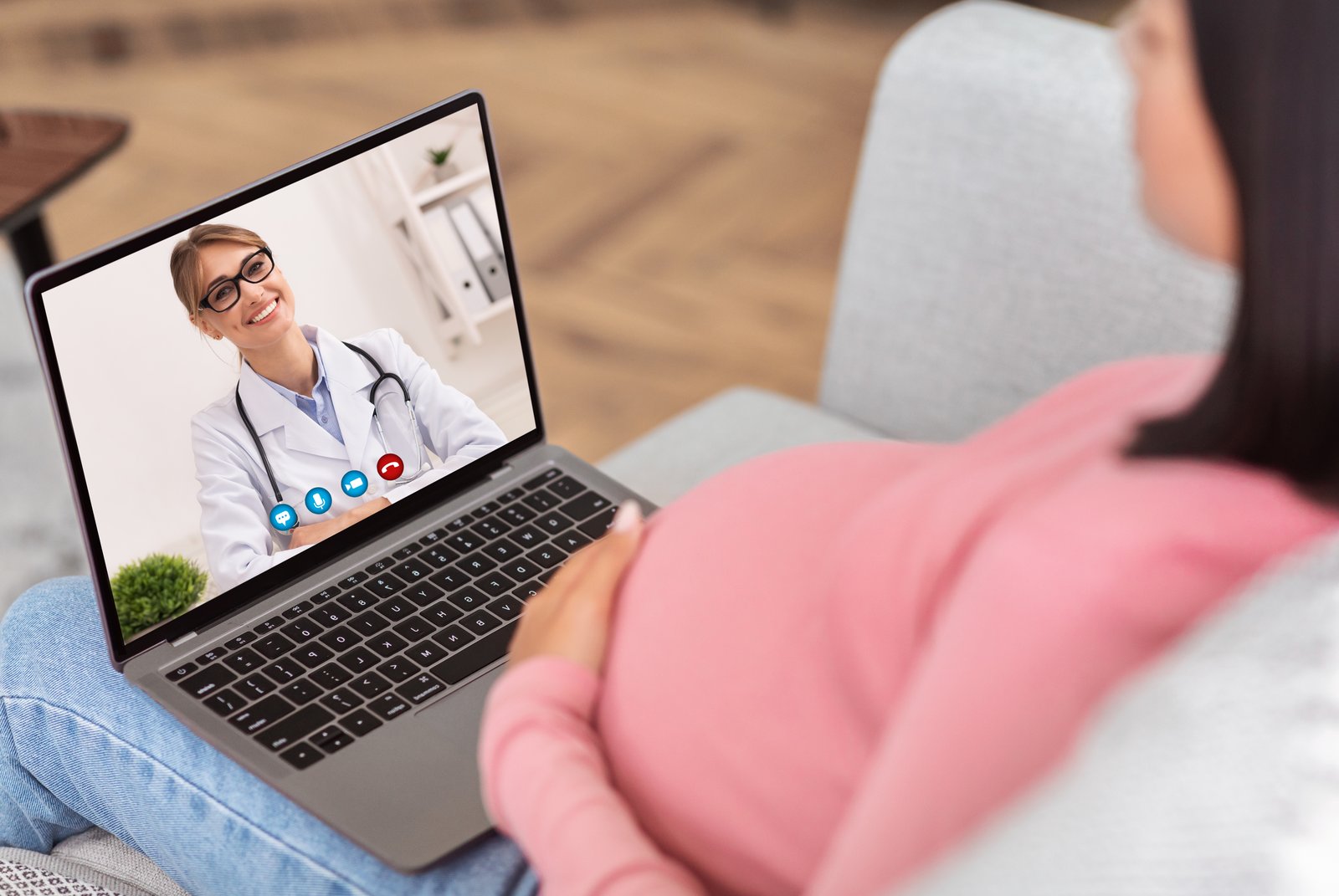 Pregnant Woman At Laptop Having Online Consultation With Doctor Indoor